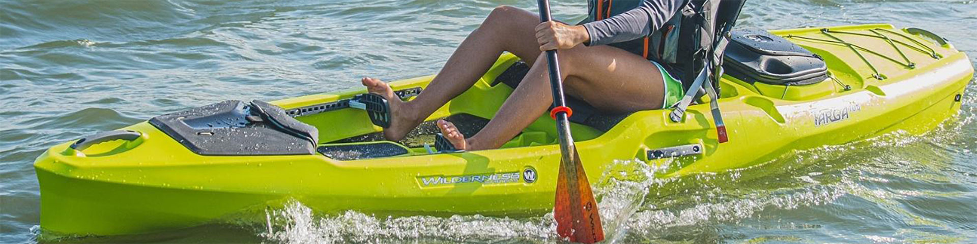 Person paddling a yellow Targa 100 kayak from Wilderness Systems