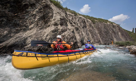 two people paddle a yellow canoe down the Broken Skull River