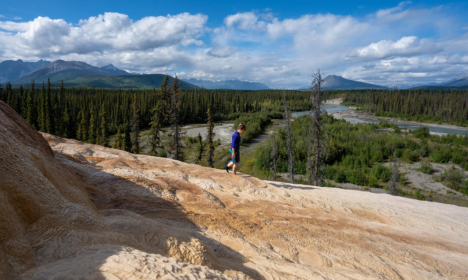 person hiking along a rocky ridge above the Upper Nahanni River